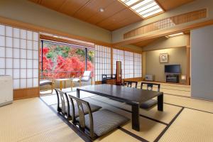 een eetkamer met een tafel en stoelen en een raam bij Ranzan in Kyoto