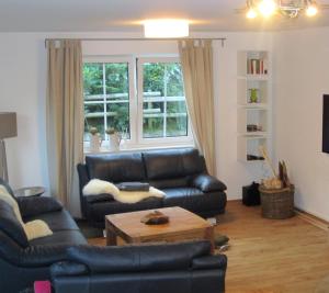 a living room with a leather couch and a coffee table at Schneekäppchen 2 in Winterberg