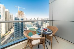 a table and chairs on a balcony with a view of a city at Icon Casa Living - Bay Central Tower Marina View I in Dubai