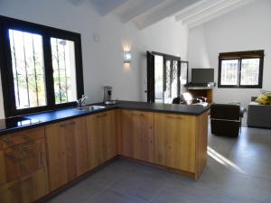 eine Küche mit einem Waschbecken und ein Wohnzimmer in der Unterkunft Casa El Teix in Altea