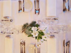 a table with plates and silverware and flowers on it at Westland Hotel in Lindås