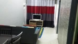 a living room with a couch and a television at Baiti Homestay in Gambang