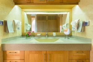 a bathroom with a sink and a large mirror at One ON Marlin Resort in Turtle Cove +36 photos