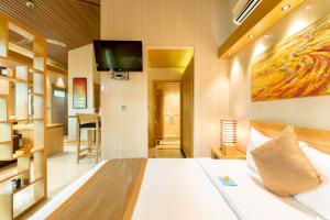 a bedroom with a bed with a tv on the wall at One ON Marlin Resort in Turtle Cove