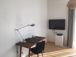 a desk with a lamp and a television in a room at La Cabane in Bouliac +7 photos