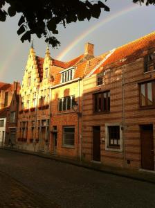a rainbow in the sky over a brick building at B&B Emma in Bruges
