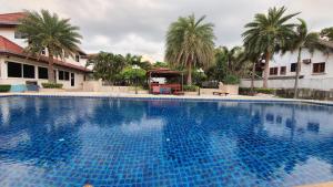 a large blue swimming pool in front of a building at Serene Sands in Bang Lamung