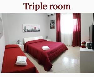a bedroom with a large red bed and a tv at Catania Suite Home in Catania