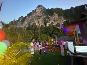 a group of people standing in front of a mountain at The Scene Cliff View Villas in Ao Nang Beach