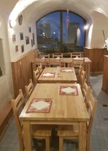 a dining room with wooden tables and chairs at LE GÎTE LES MELEZES in Villar-dʼArène