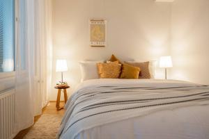 a bedroom with a large white bed with two lamps at Roost Rantatie 18 in Tampere