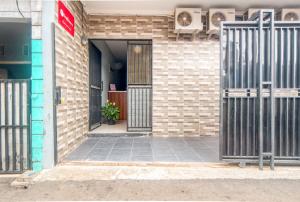 an open door of a brick building with a gate at RedDoorz near Graha Cijantung Mall in Jakarta