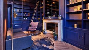 a blue room with a chair and a fireplace at Staybridge Suites The Hague - Parliament, an IHG Hotel in The Hague