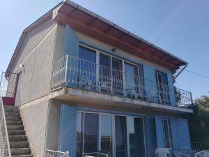 a house with a balcony and stairs at Cozy studio #1, with balcony in 2 Mai