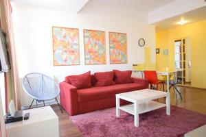 ein Wohnzimmer mit einem roten Sofa und einem Tisch in der Unterkunft Mosilor Apartments in Bukarest