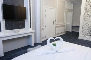 een hotelkamer met twee witte zwanen die een hart vormen bij VARIMANTRA HOTEL in Nakhon Pathom