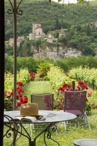 a table and chairs in a field of flowers at Hôtel-Spa Le Saint Cirq in Tour-de-Faure