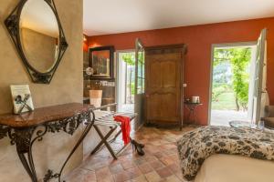 
a room with a bed, chair, table and a mirror at Hôtel-Spa Le Saint Cirq in Tour-de-Faure
