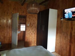 a bedroom with a bed and a tv on a wall at Lauren Palace Guest House in Vanderbijlpark
