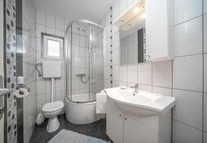 a white bathroom with a sink and a toilet at Adria Sun Apartments in Vodice +31 photos