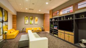 sala de estar con muebles de color amarillo y TV de pantalla plana. en Holiday Inn San Francisco - Golden Gateway, an IHG Hotel en San Francisco