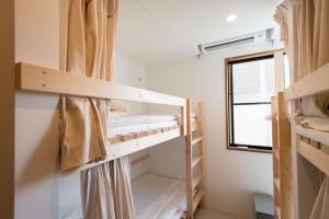 Zimmer mit Etagenbetten und Fenster in der Unterkunft plumhostel in Odawara