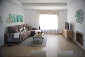 een woonkamer met een bank en een tv bij Casa de la Jara 10 in Sanlúcar de Barrameda