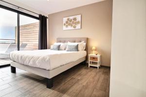 a bedroom with a large bed and a balcony at Residence ACQUA LINDA Porticcio in Porticcio