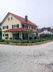 una casa con techo rojo al lado de una carretera en Winzerhof Schwerdt, en Bad Dürkheim