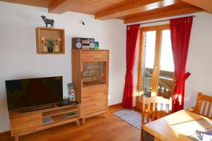 a living room with a flat screen tv and a table at Bergbauernhof Weber in Bad Hindelang