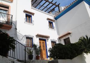a white house with a blue door and stairs at Casa Amaya Rústico en Ojén in Ojén