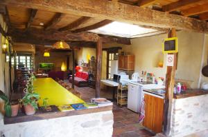 a kitchen and a living room with a counter top at Le Grangé in Giscaro