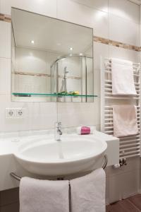 a white bathroom with a sink and a mirror at Gästehaus Steger in Kaprun