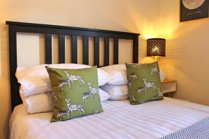 um quarto com uma cama com duas almofadas verdes em Castlehill Apartment em Stirling