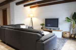 sala de estar con 2 sofás y TV de pantalla plana en Cave du Cep, en Cortaillod
