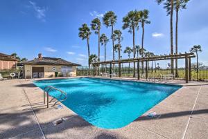 a swimming pool with palm trees in the background at South Padre Paradise with Saltwater Pool Near Golf! in Laguna Vista