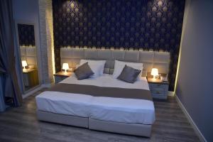 a bedroom with a large bed with two night stands at The King Resort in Tirana