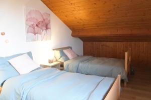 um quarto com 2 camas e um tecto de madeira em Cave du Cep em Cortaillod