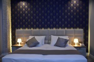 a bedroom with a large bed with two lamps at The King Resort in Tirana