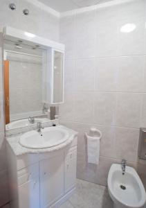 a bathroom with a sink and a toilet and a mirror at Apartaments Can Xel in Santa Pau