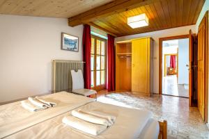 a bedroom with a bed with towels on it at Chalet SONNECK Summer Card included in Kaprun