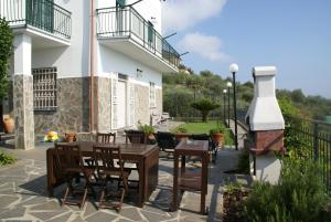 een patio met een tafel en stoelen en een gebouw bij Sarina House Ocean View in Lavagna