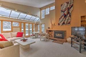 Una sala de estar con un sofá y una chimenea. en Ski-InandSki-Out Winter Park Condo with Pool Access!, en Winter Park
