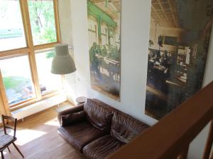 sala de estar con sofá de cuero y lámpara en Zur alten Scheune, en Balingen