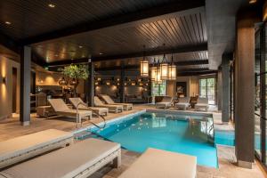a pool in a hotel with chairs and a bar at Van der Valk Hotel Apeldoorn - de Cantharel in Apeldoorn