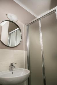 uma casa de banho com um chuveiro, um lavatório e um espelho. em Vernazza2010 Rooms em Vernazza