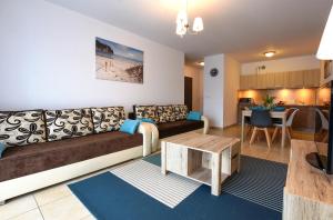 a living room with a couch and a table at Apartamenty PROMENADA - Aquarius in Kołobrzeg