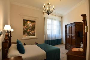 烏貝達的住宿－瑪麗亞·莫利納酒店，卧室配有一张床,墙上挂有绘画作品
