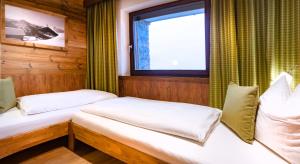 2 Betten in einem Zimmer mit Fenster in der Unterkunft ArtiHome in Hopfgarten im Brixental