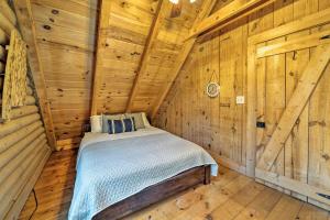 een slaapkamer met een bed in een houten hut bij Secluded Cabin with Fishing Pond near Hunting! in Bessemer